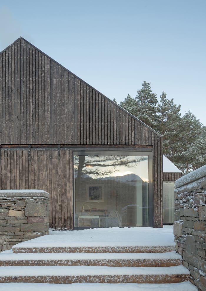 Lochside House exterior in the snow, showing large, full height picture window, RIBA Awards 2018