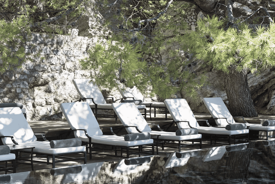 Aman Sveti Stefan hotel, cliff pool with stone wall, pine trees and sun loungers