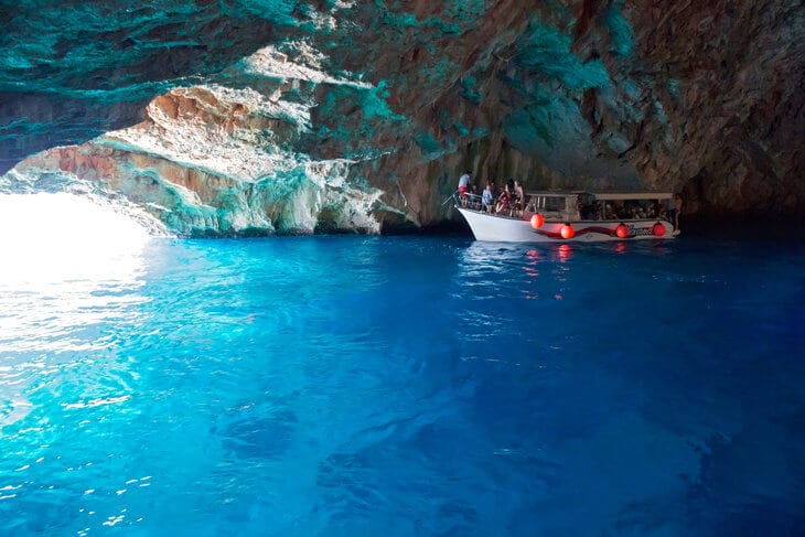 Lustica Peninsula Montenegro, inside the Blue Cave with iridescent blue water and one boat