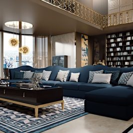 Luxurious living room featuring a large blue sectional sofa adorned with patterned throw pillows, a dark wooden coffee table with decorative items, an elegant chandelier, tall bookshelf, and floor-to-ceiling windows offering a cityscape view.