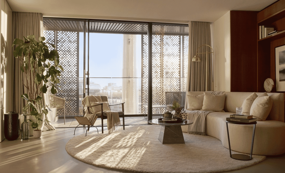 Gasholders interior with contemporary furniture, showing perforated screen partly drawn across full height window, RIBA Awards 2018