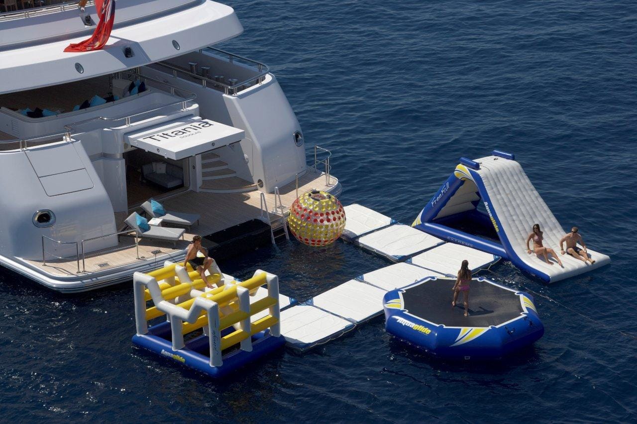 Yacht toys, back of Titania super yacht showing sea pool, zorb, slide, trampoline and obstacle