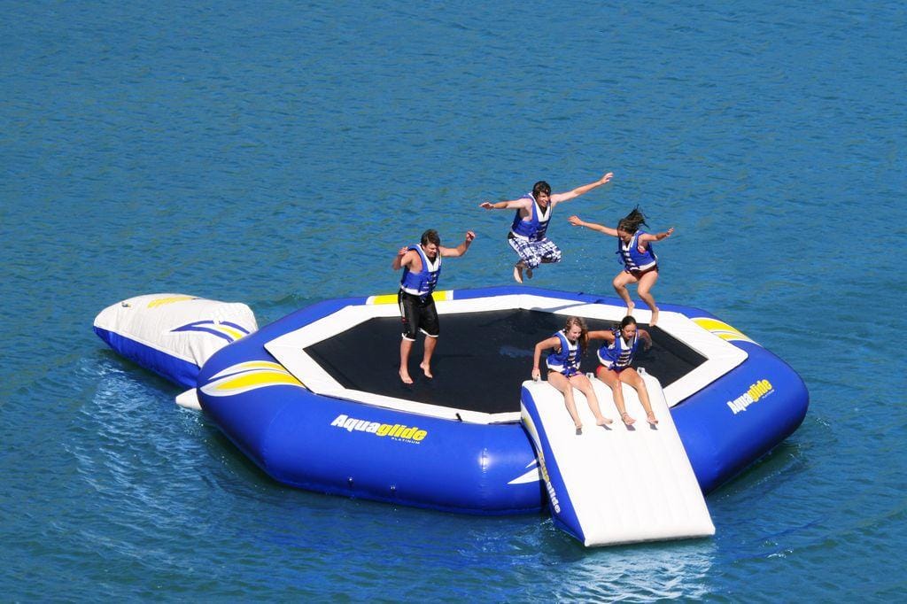 Yacht toys, connected trampoline with slide and air cushion, people bouncing and sliding into the sea