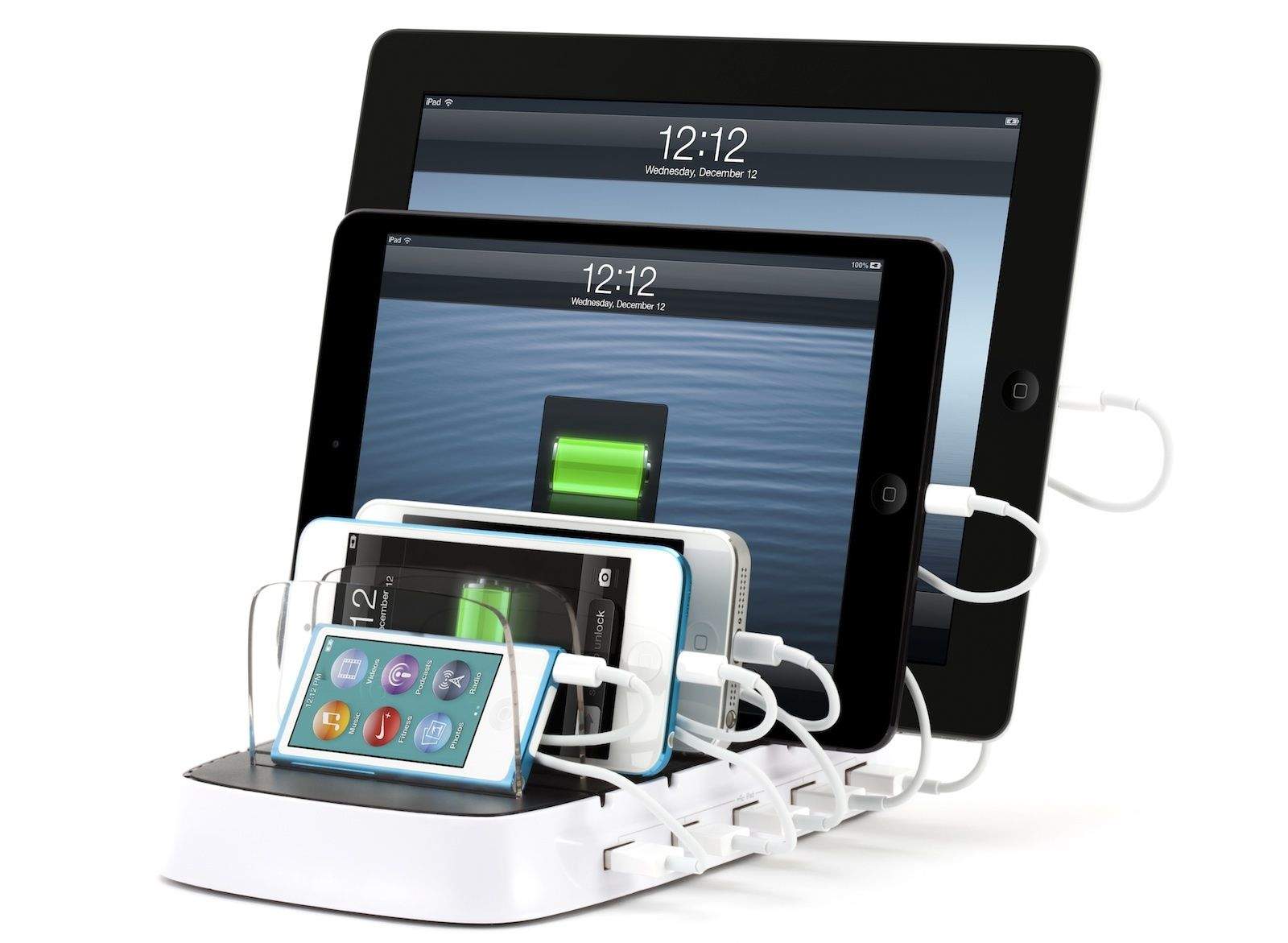 A multi-device charging station with multiple slots holds and charges several electronic devices including tablets and smartphones. Each device is connected by a white USB cable, showcasing their charging screens. The time displayed is 12:12. Be the perfect host by keeping all your guests’ devices powered up.