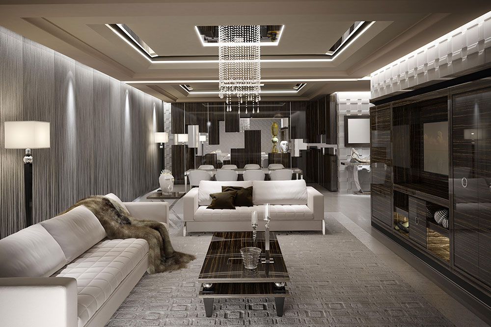 A modern living room with luxurious decor. It features a white couch, a dark coffee table, and a crystal chandelier. The room has a dining area in the background with a table and white chairs. Bespoke furniture enhances the walls and ceiling, which have sophisticated lighting and wooden accents.