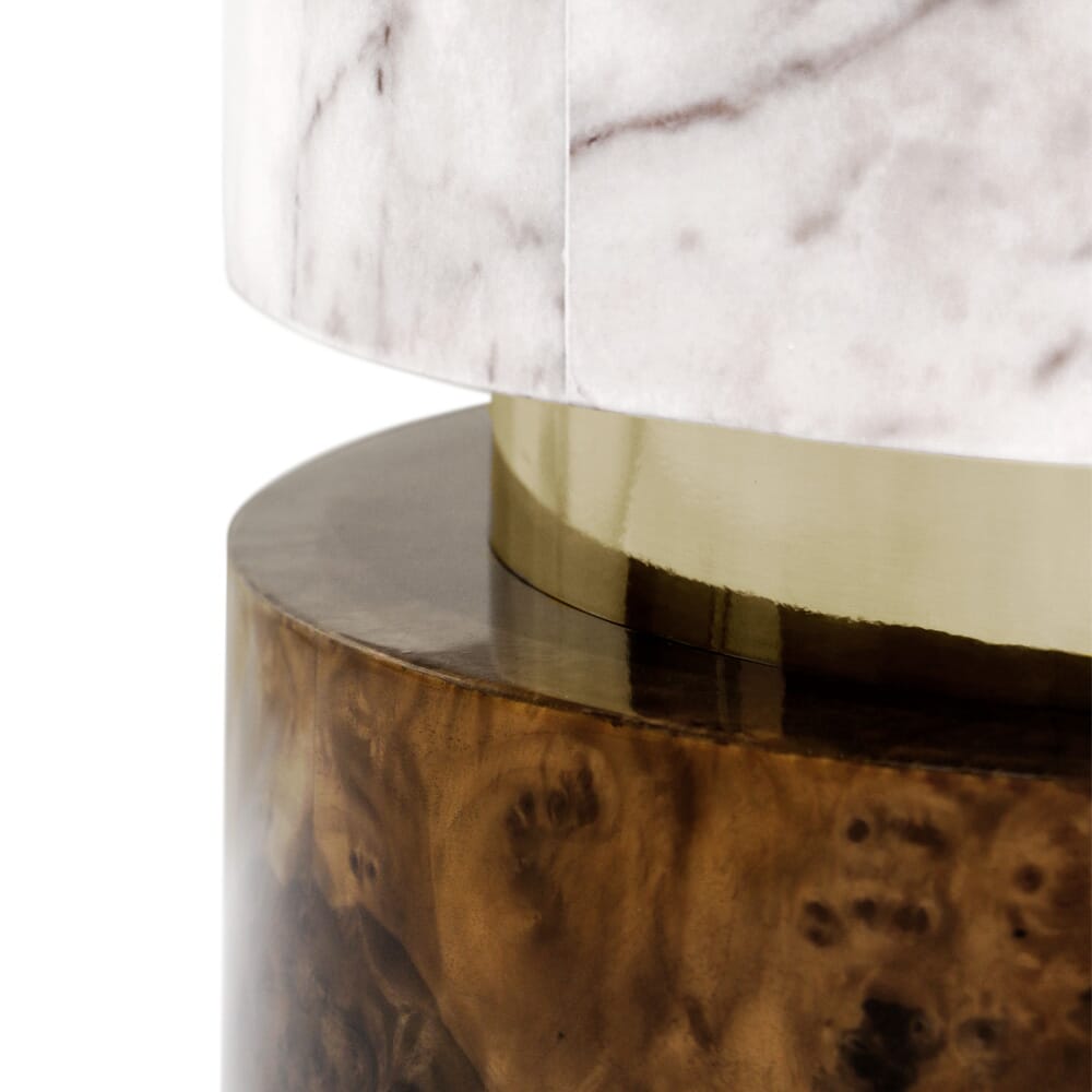 Close-up of a lamp base from our luxury furniture collection, featuring a combination of materials. The lower part shows a textured, dark brown wood finish, the middle section has a smooth, gold metallic band, and the upper part displays a white and grey marble design.