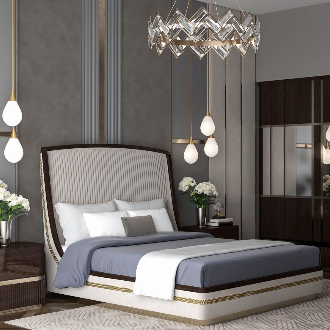 A modern luxury bedroom interior design featuring a luxurious upholstered bed with a high, curved headboard. It is adorned with white linens, a gray blanket, and decorative pillows. The room has pendant lights, a crystal chandelier, bedside tables with plants, and mirrored wardrobes.