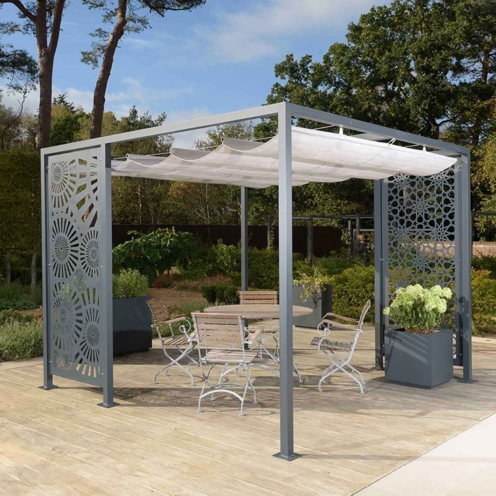 A modern outdoor gazebo with decorative metal panels and a retractable fabric shade cover. Beneath the gazebo, there is a wooden table and chairs set, perfect for dining in your luxury garden. The area is surrounded by a lush garden with various plants and trees, and a wooden deck extends from the gazebo.