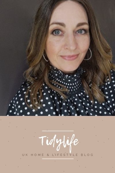 A woman with long brown hair wearing a black polka dot top smiles softly. The text below her reads "Tidylife" with the tagline "UK Home & Lifestyle Blog" on a beige background, featuring insights from an online interior design course.