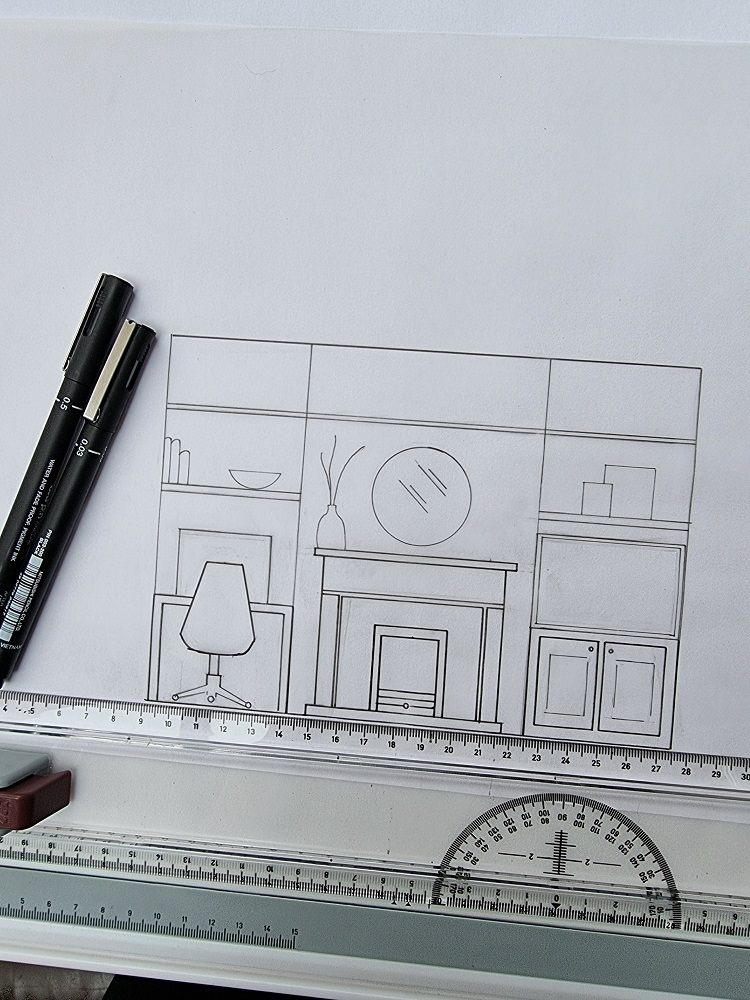 A technical drawing of a living room setup, ideal for an interior design course, includes a chair, a fireplace, and shelves with decor items. Two black pens are placed on the left side of the paper. The drawing tools like a ruler and protractor are visible at the bottom.