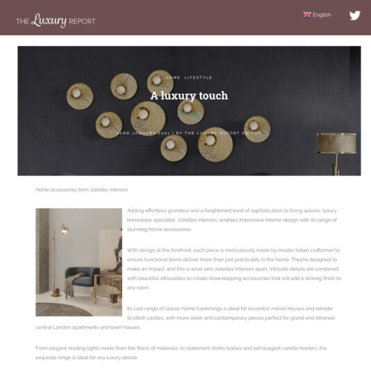 Screenshot of an article from The Luxury Report titled "A luxury touch," featuring circular golden wall decor items. The article discusses luxurious home accessories from Juliettes Interiors, including an elegant room setup with a stylish armchair, side table, and lamp.