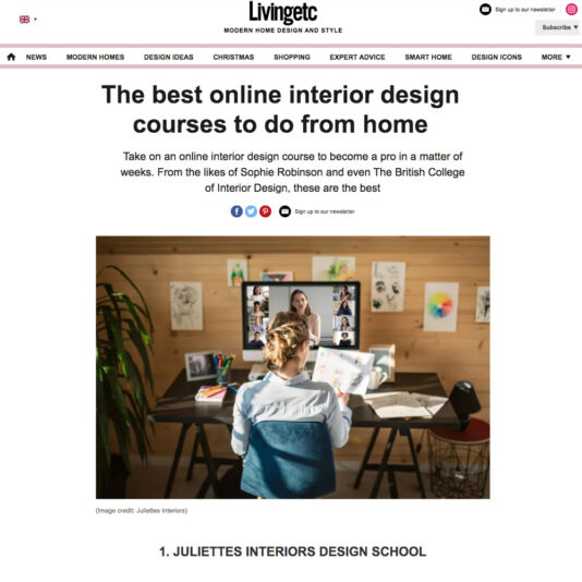 A woman sits at a desk with a monitor, participating in an online interior design course. The screen shows a virtual classroom with multiple participants. The setting is a home office with wooden walls, decorated with framed pictures and plants. Text above the image reads "The best online interior design courses to do from home.