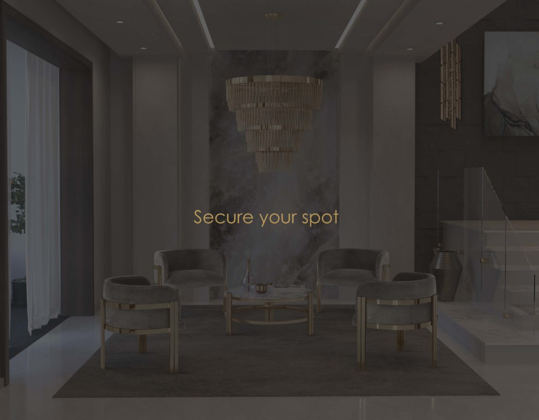 A luxurious, modern lobby featuring a gray rug, four gray velvet chairs with gold accents arranged around a glass coffee table, and a large, elegant chandelier hanging from the ceiling. Text in the center reads "Secure your spot and become your own interior designer.