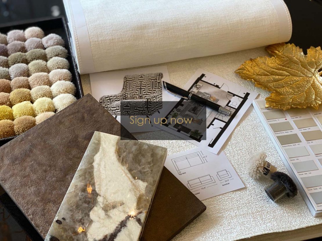 A workspace with interior design materials, including a sample book of fabric swatches, a roll of wallpaper, architectural plans, tile samples, and a golden leaf decor piece. Perfect for planning your dream space with al-fresco entertaining tips—"Sign up now" to get started!