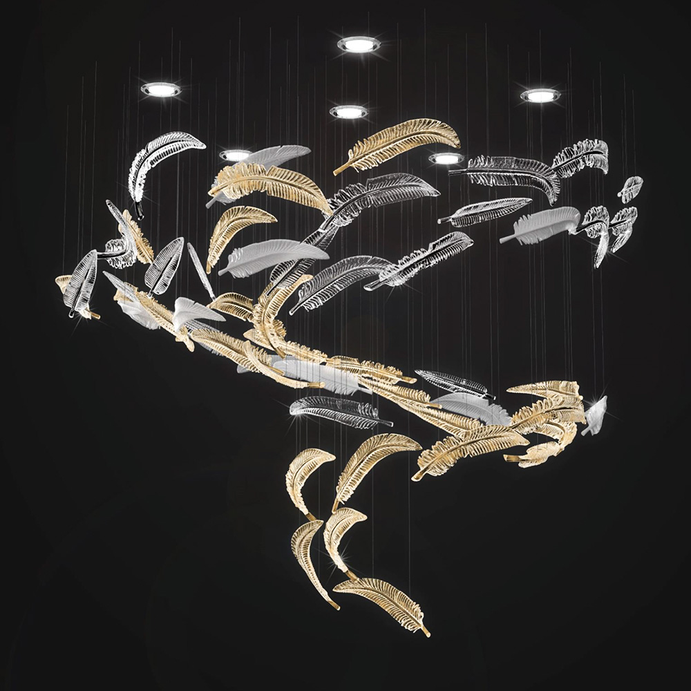 A chandelier featuring an intricate arrangement of translucent and gold leaves, elegantly suspended from the ceiling. This sculptural lighting forms a swirling pattern, creating a cascading effect under several small spotlights against a dark background, instantly transforming your home.