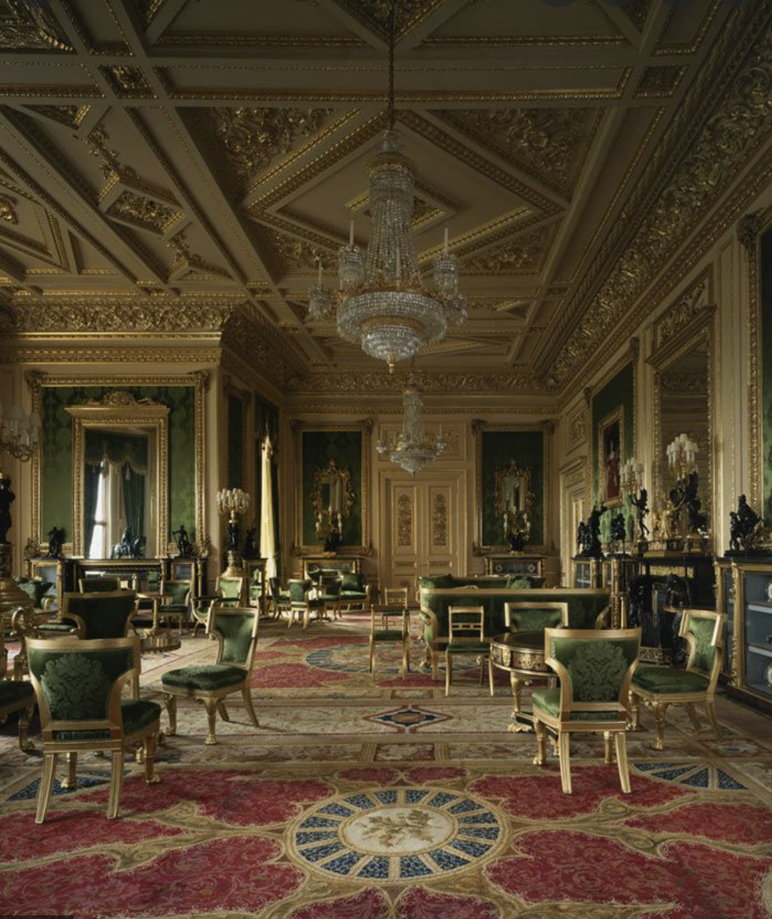 Lavishly decorated room with ornate golden ceilings, chandeliers, and intricate moldings. Echoing the grandest rooms of Queen Elizabeth, it features green and gold upholstered chairs, fine artwork, and an elaborate red and beige patterned carpet. Large mirrors and tall windows add sophistication.