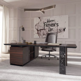 A modern office with a sleek black desk and an ergonomic chair. Behind the desk is a large wall art piece that reads "Happy Father's Day." The room features a geometric pendant light and ample natural light from a window with sheer curtains—truly one of the best luxury Father's Day gifts.