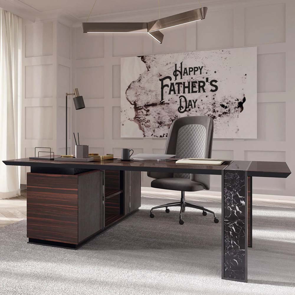 Modern office setting with a large wooden desk and a black leather chair. The desk has minimalist decor and office supplies. A large "Happy Father's Day" sign is displayed on the wall behind the desk, showcasing one of the best luxury Father's Day gifts he could receive. Light filters in through sheer curtains on the left.