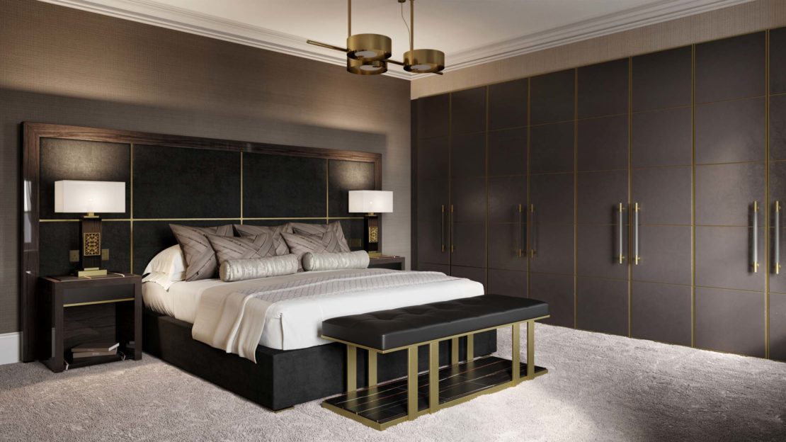 A luxurious bedroom in a gentleman's luxury home features a king-sized bed with a tufted headboard, outfitted with pillows and a throw blanket. Flanking the bed are bedside tables with lamps. There's a bench at the foot of the bed, and the room has large closets and modern lighting.