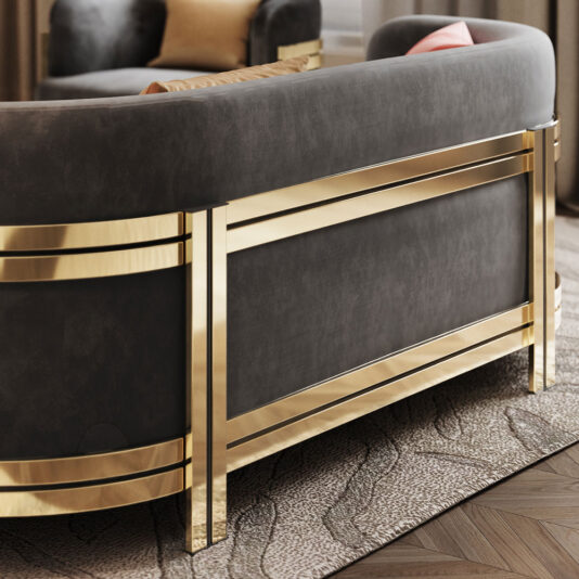 Modern Curved Sofa With Brass Frame A close-up of the **Modern Curved Sofa With Brass Frame** showcases its luxurious design with a dark backrest elegantly enclosed by the brass frame. The sofa is situated on a textured carpet, with part of a cushioned chair visible in the background.