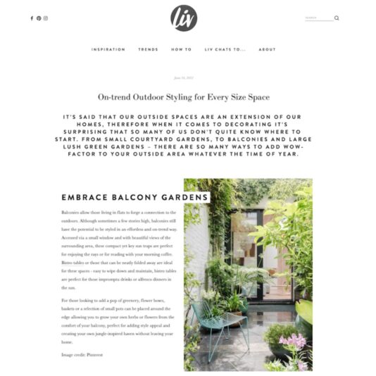 An online article titled "On-trend Outdoor Styling for Every Size Space," featuring a photograph of a cozy balcony garden with lush green plants and stylish outdoor furniture. The design integrates natural elements, creating a serene and inviting outdoor living area.