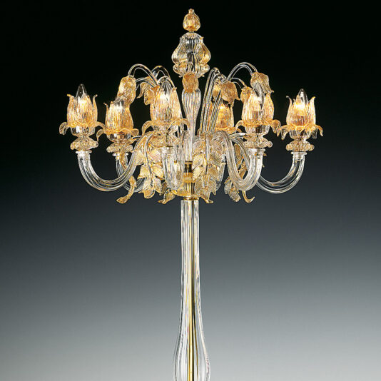 The Classic Floral Gold Glass Floor Lamp stands tall and elegant with eight intricately designed, curved glass arms that extend outwards, each holding a candle-like light encased in floral-shaped glass. The classic fixture casts a golden glow against a dark background when illuminated.