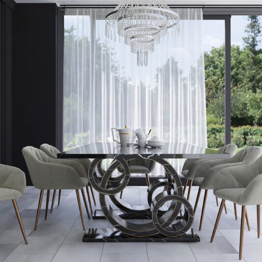 Exclusive Rectangular Marble Dining Table A modern dining room showcases the Exclusive Rectangular Marble Dining Table, which boasts a unique abstract metal base. Surrounding it are eight light gray cushioned chairs with wooden legs. Above the table hangs a large, elegant crystal chandelier, and floor-to-ceiling windows dressed in sheer white curtains reveal a lush green garden outside.