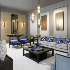 Modern living room with grey walls, a white carpet, and neutral-toned furniture. Features a grey sofa with blue and white cushions, digital lavender armchairs, a black coffee table, and hanging pendant lights. Contemporary wall art and a mirror are also present.