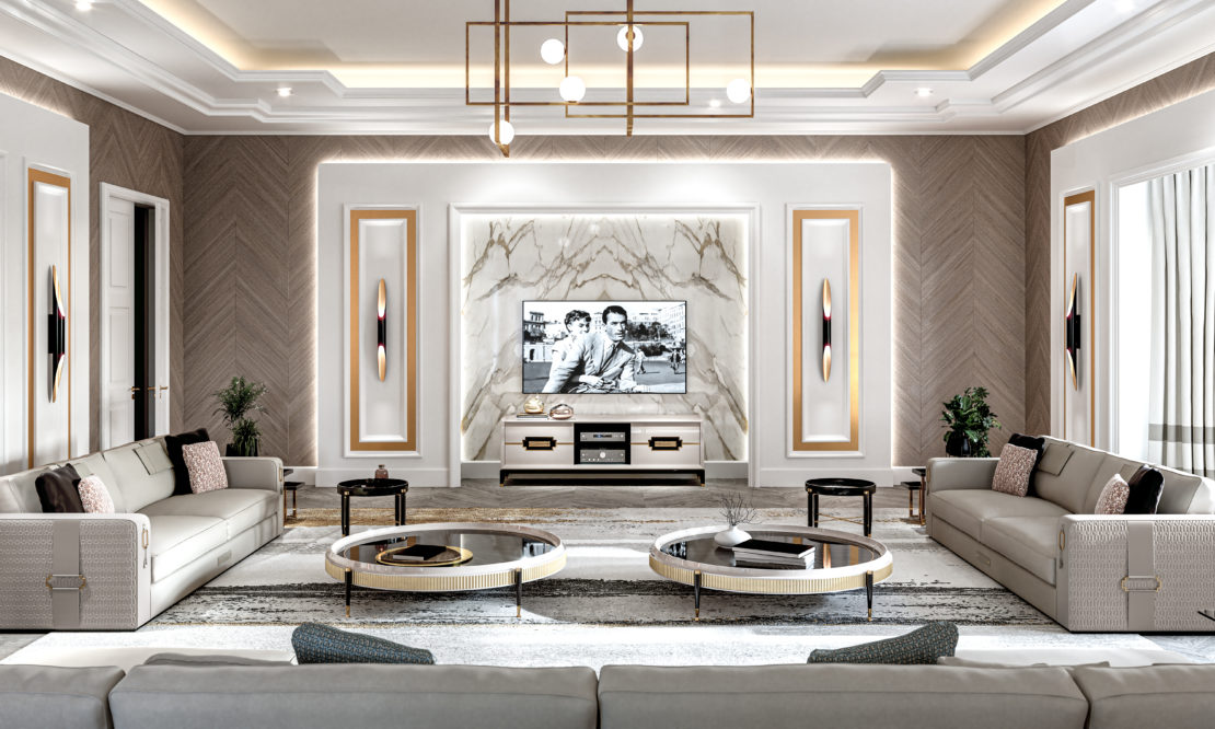 A modern, luxurious living room with a large wall-mounted TV displaying a black and white image. The room features two elegant beige sofas, a marble accent wall, geometric light fixtures, and round coffee tables with gold accents. Decorative plants and wall art complete the space.