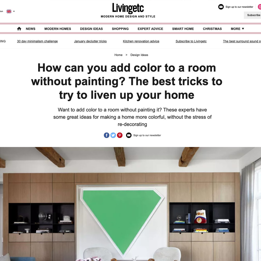 A webpage from Livingetc with the header "How can you add color to a room without painting? The best tricks to try to liven up your home." Discover creative ways to add color to a room without painting, featuring a subheader and decorative shelves against a wooden wall. Various navigation links and social media icons are visible.