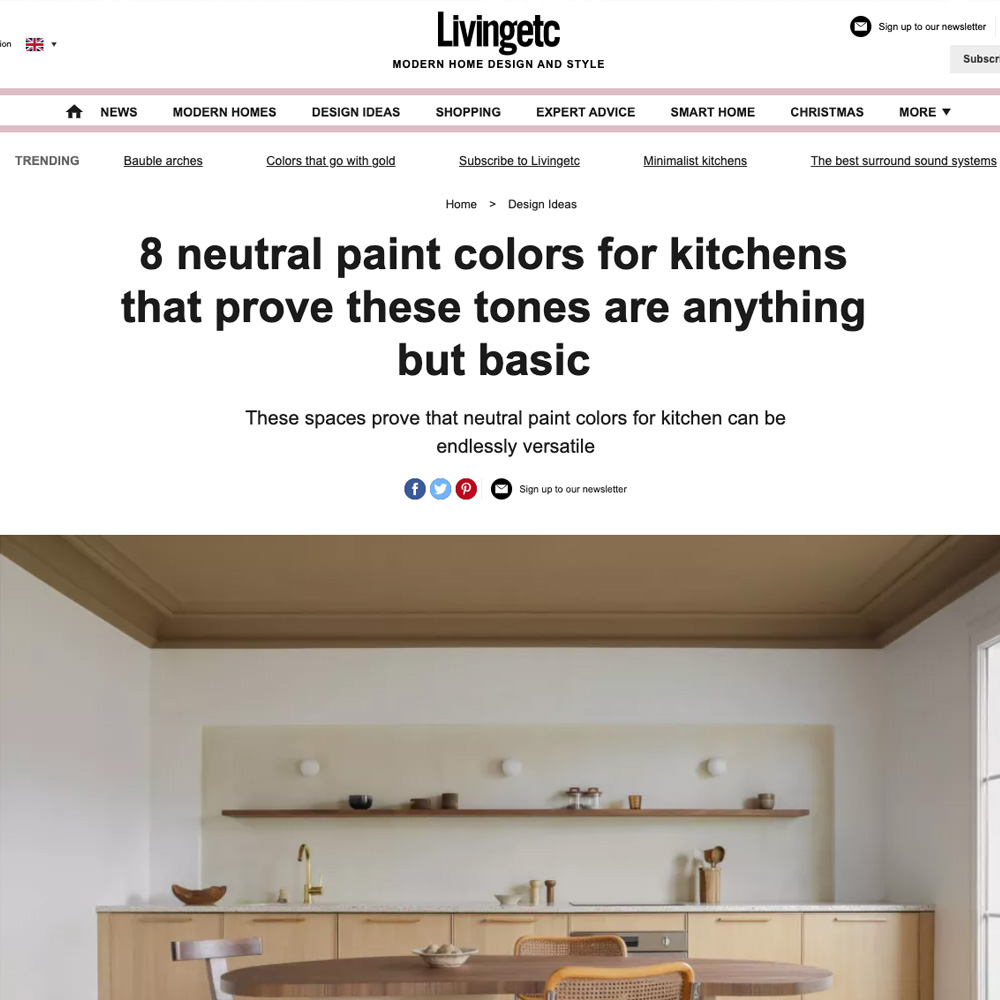 A screenshot of a webpage from Livingetc with the headline "8 neutral paint colors for kitchens that prove these tones are anything but basic." The page features a minimalist kitchen with 8 neutral paint colors, a wooden table with chairs, and a shelf adorned with decor items.