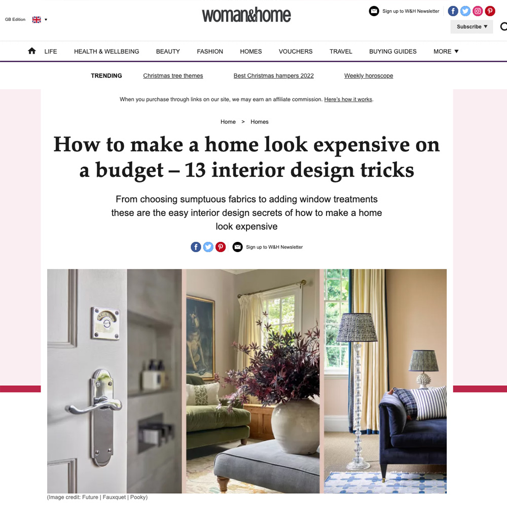 A webpage from "woman&home" titled "How to make a home look expensive on a budget – 13 interior design tricks." The page showcases a doorknob, a stylish living room with a couch and lamp, against a backdrop of elegant home decor and design elements.