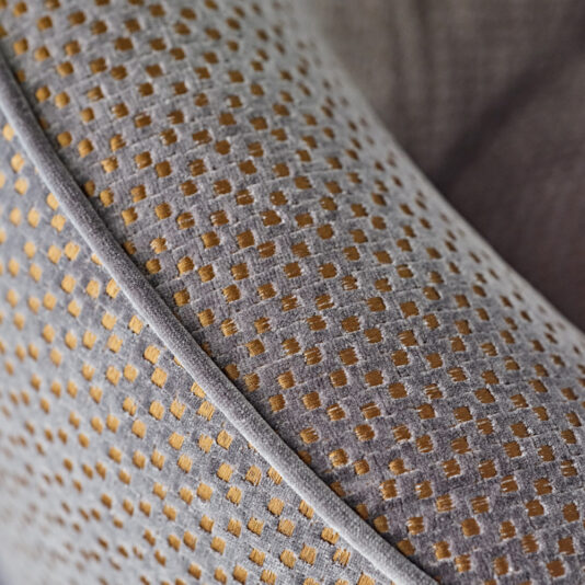 Modern Luxury Swivel Armchair Close-up of the Modern Luxury Swivel Armchair's textured fabric, featuring a pattern of small, golden yellow squares on a gray background. The detailed stitching and exquisite upholstery texture are prominently showcased.