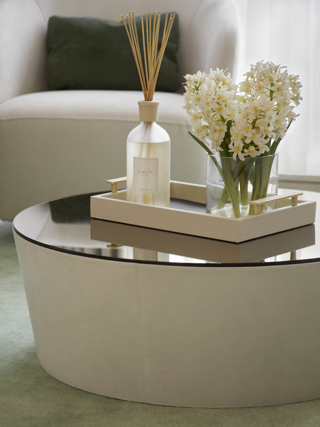 Round glass topped coffee table with flowers and fragrance diffuser