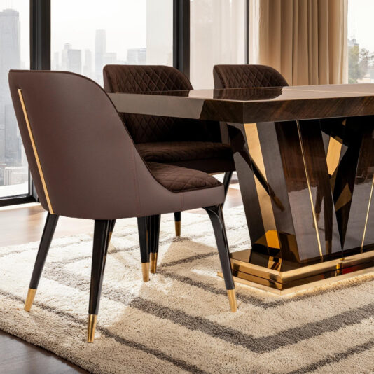 The dining room features a sleek dark wood table with gold accents, complemented by four Exclusive Modern Quilted Dining Chairs. Floor-to-ceiling windows reveal stunning city views, while a light-colored rug softens the dark hardwood floors.