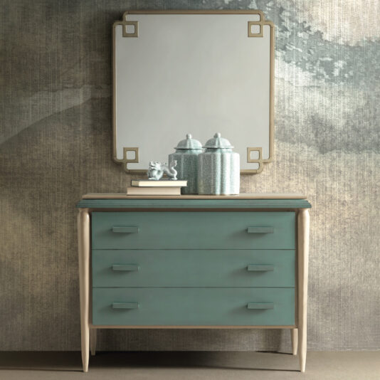 Luxury Art Deco Style Chest Of Drawers The Luxury Art Deco Style Chest Of Drawers boasts a teal-colored body and three spacious drawers, beautifully adorned with vintage decor containers and a figurine on top. Complementing this piece, a square mirror with a geometric frame hangs against an abstract-designed textured wall.