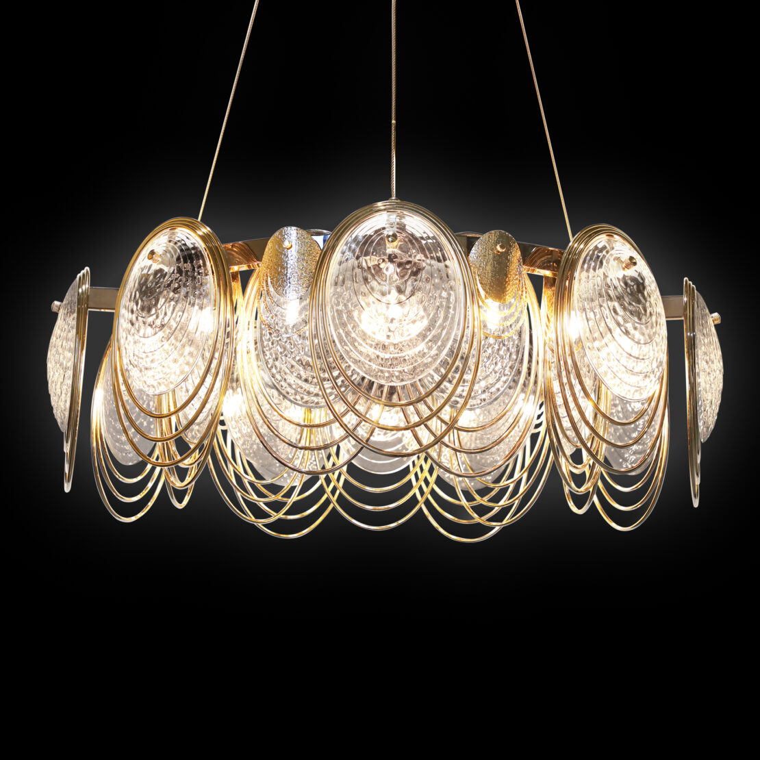 The Large Leaf Chandelier With Crystal Drops (Copy) features concentric gold rings, crystal drops, and textured glass discs. It emits bright white light and is suspended dramatically against a black background.