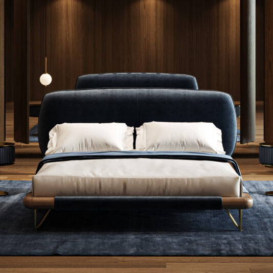 A modern bedroom showcases the Contemporary High-End Italian Bed in navy blue upholstery with a wooden frame and gold accents, paired with white bed linen. Wood-panelled walls, mirrors, soft lighting, and a blue rug complete the space.