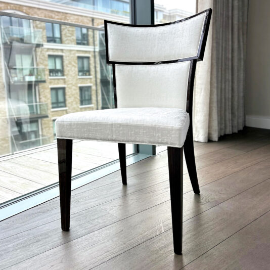 Upholstered Art Deco dining chair beside a window