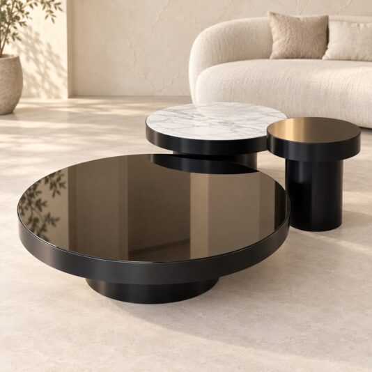 Modern round coffee table set showing the large black glass, medium marble-effect porcelain and small black tables in a neutral interior.