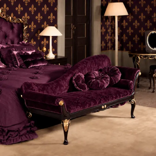 Reproduction whimsygothic chaise longue with plum patterned upholstery and dark wood in a bedroom